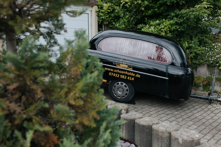 Bestattungsfahrzeug zur Überführung von verstorbenen Haustieren ins Tier-Krematorium vor der Pauluskirche Albstadt Pfeffingen in der Nähe von {{city}} im Kreis {{district}} - Die schönste Art der Tierbestattungen in {{state}}
